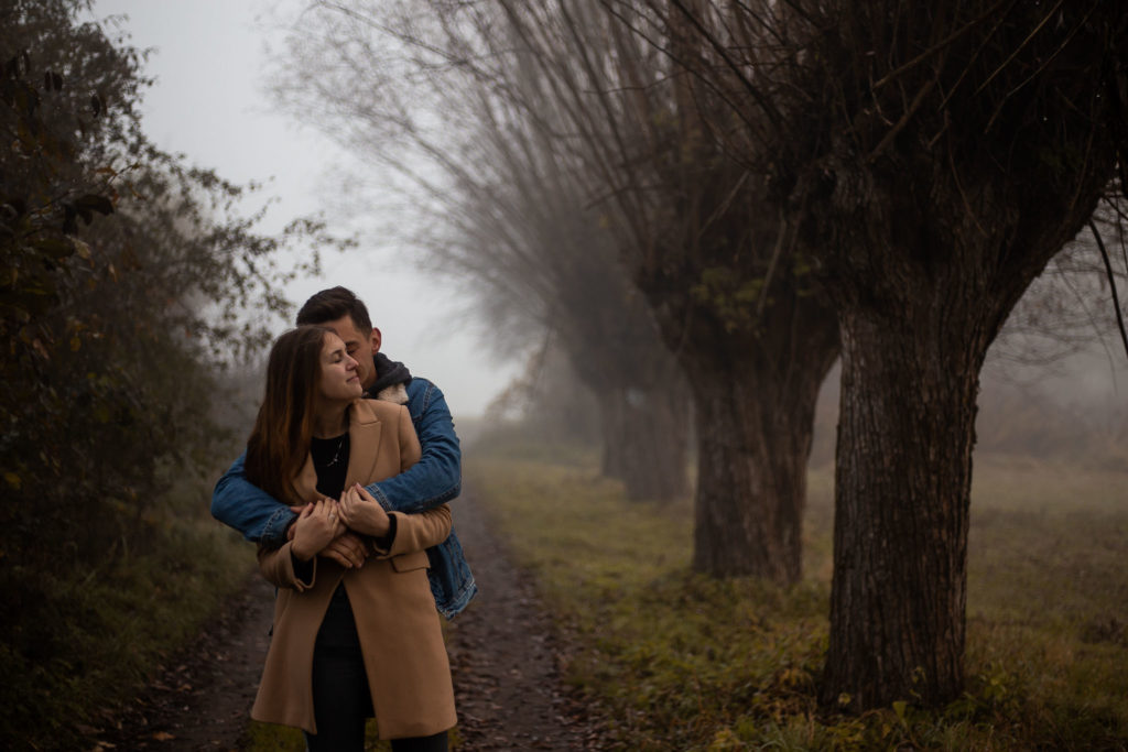 para zakochanych tuląca się we mgle między drzewami