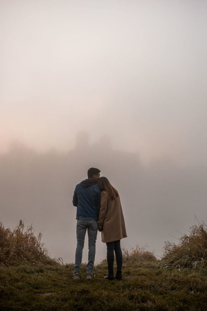 para zakochanych stojąca we mgle o wschodzie słońca