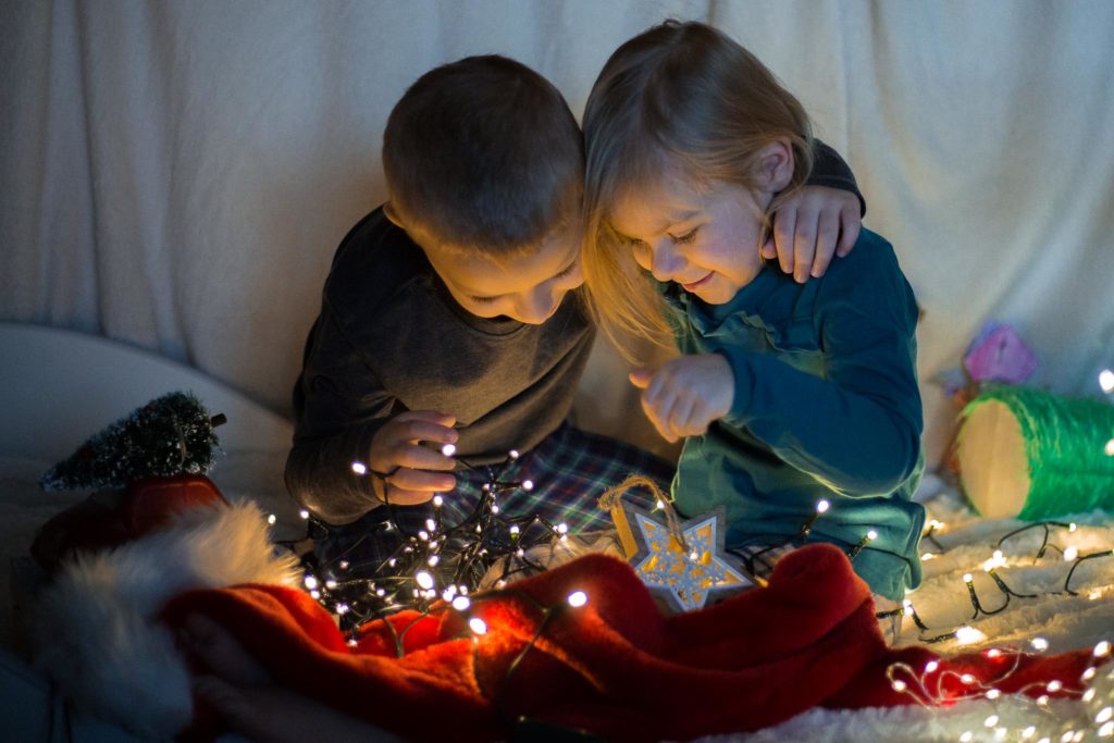 Dzieci tulące się przy świetle lampek