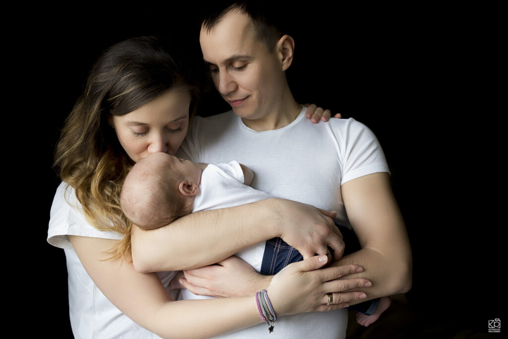 Mama i tata tulą w ramionach swojego syna, sesja noworodkowa
