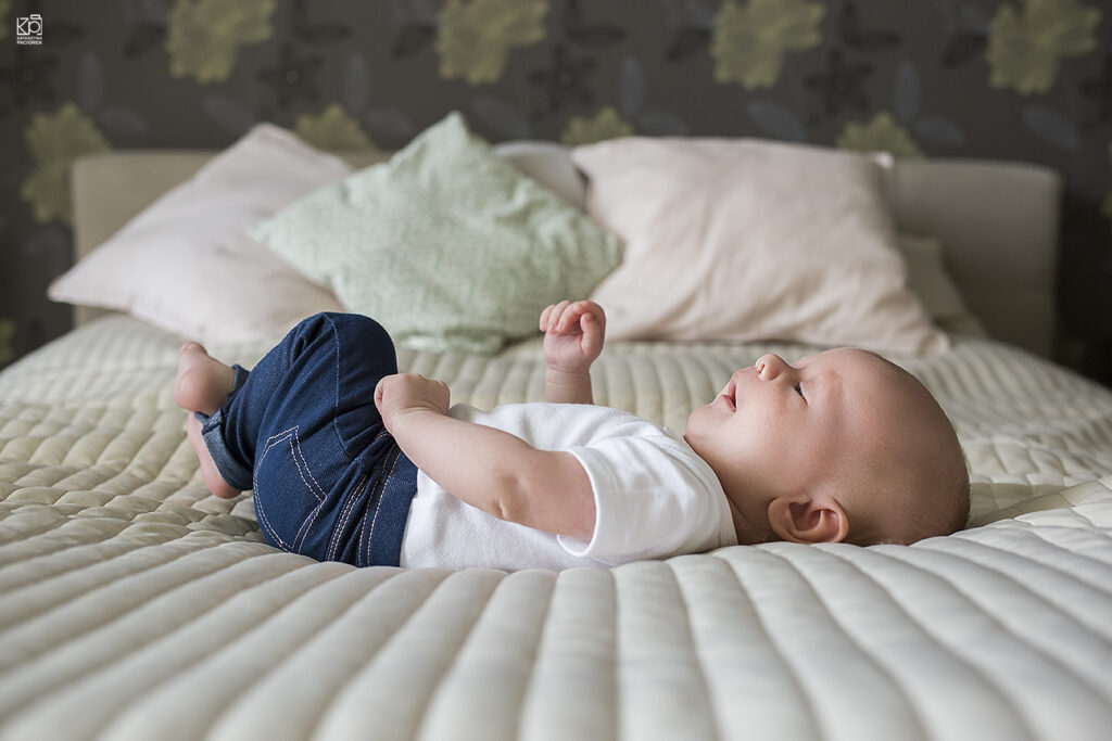 noworodek leżący na łóżku podczas sesji zdjęciowej