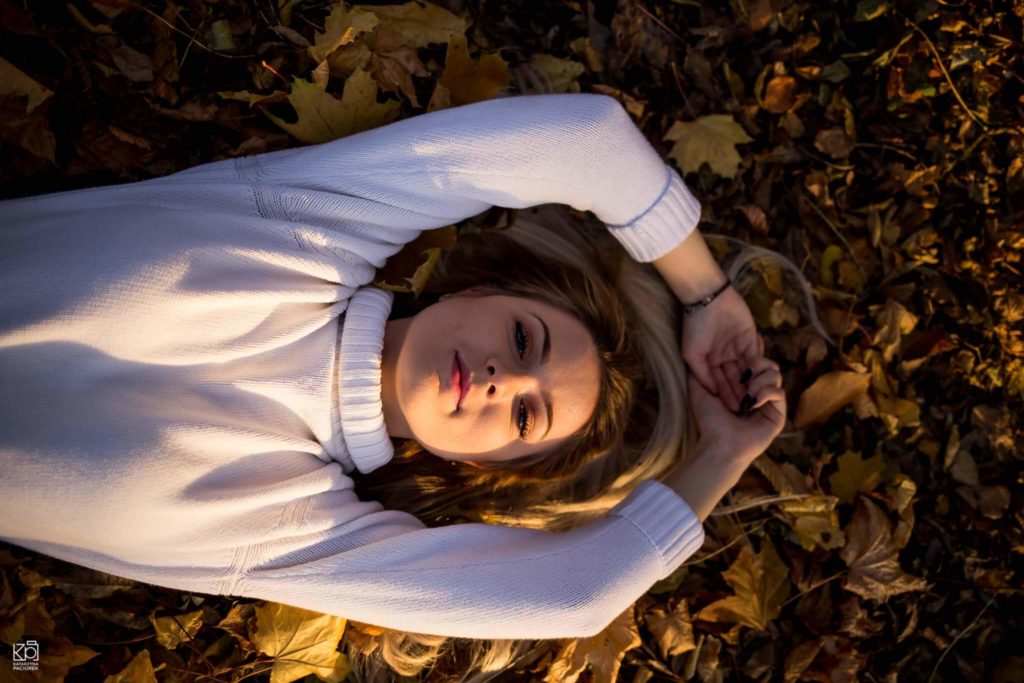 Kobieta leżąca na jesiennych liściach