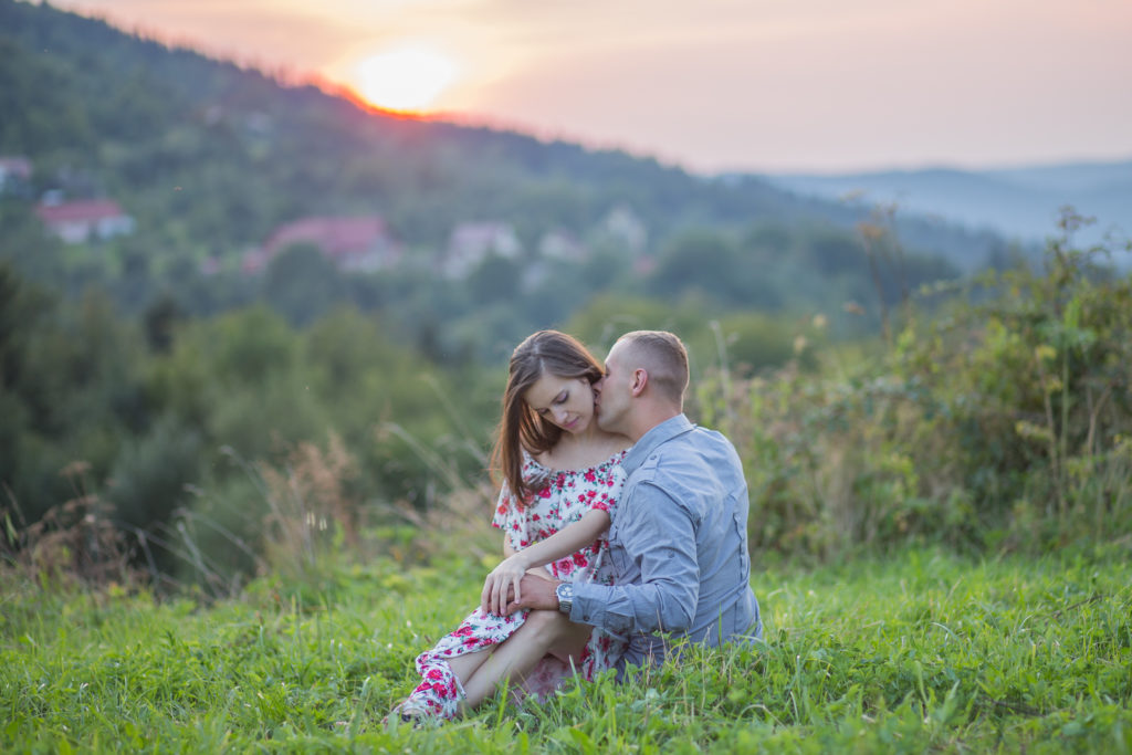 mężczyzna całuję kobietę w szyje przy zachodzie słońca, katarzynapaciorek.pl