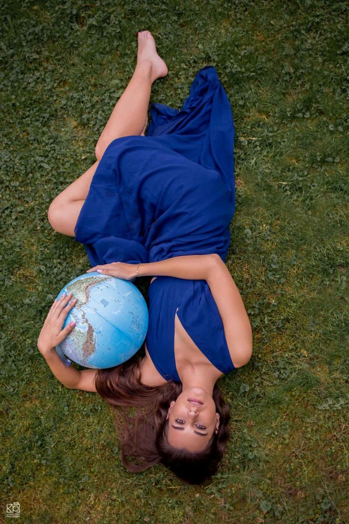 Kobieta w niebieskiej sukience tuląca globus