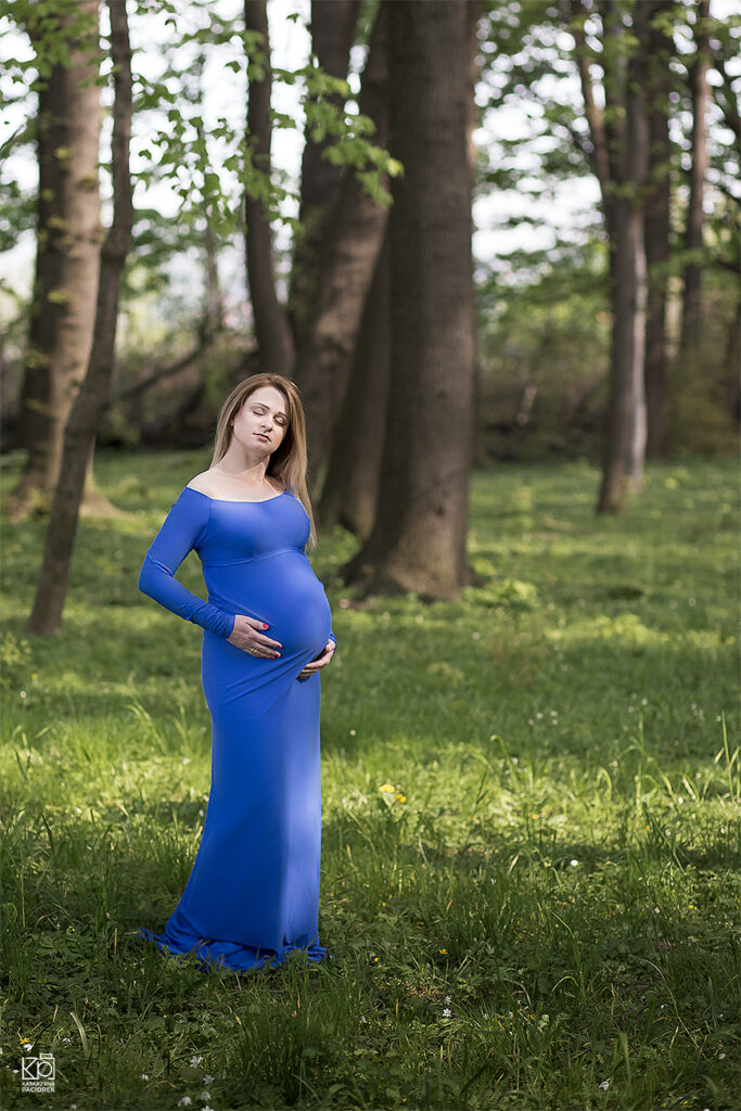 Fotografia ciążowa przedstawiająca kobietę obejmującą dłońmi brzuch