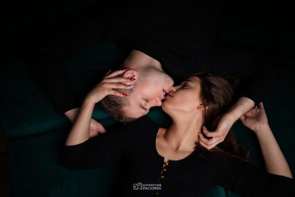 Kobieta i mężczyzna leżą na łóżku, stykają się ustami
